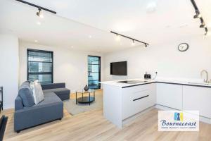 a kitchen and living room with a couch and a table at Bournecoast - Brand New Clifftop Apartment with Balcony - FM9574 in Bournemouth