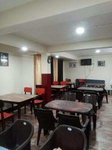 a restaurant with tables and chairs and a flat screen tv at HOTEL TASHI NORLING Near Mall Road in Gangtok