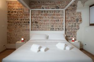 a bedroom with a white bed with two white pillows at Verona Design in Verona