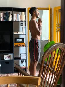 un hombre sin camisa parado frente a una puerta en Sobrado Fundição, en Recife