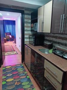 a kitchen with a sink and a door to a living room at Pyramids Porto El Sokhna Familis Only in Ain Sokhna