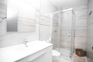 baño blanco con ducha y lavamanos en Pensión Caldas, en Caldas de Reis
