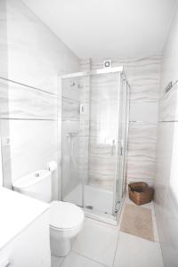 カルダス・デ・レイスにあるPensión Caldasの白いバスルーム(シャワー、トイレ付)