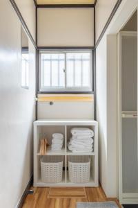 a bathroom with white towels on a shelf at SKY GATEスカイツリー徒歩3分の貸切ヴィラ/成田羽田直通/浅草徒歩15分 in Tokyo +81 photos