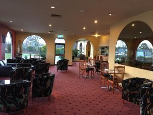 een eetkamer met tafels, stoelen en ramen bij Bell Tower Inn in Ballarat