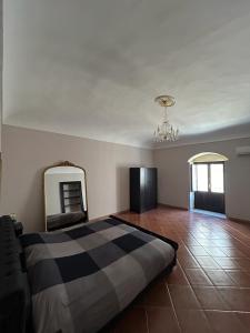 ein Schlafzimmer mit einem großen Bett und einem Spiegel in der Unterkunft Cavour69 in Avola