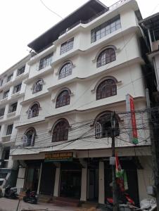 Un grand bâtiment blanc avec des fenêtres donne sur une rue. dans l'établissement HOTEL TASHI NORLING Near Mall Road, à Gangtok