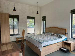 een slaapkamer met een bed en een tafel en ramen bij Terra Cottage in Palāhu
