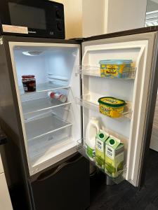 a refrigerator with its door open with food inside at Blackwood Residence in Accrington