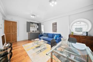 a living room with a blue couch and a table at Apartment 5, 48 Bishopsgate by City Living London in London