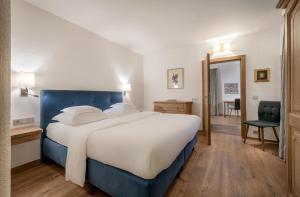 1 dormitorio con 1 cama grande y 1 silla en Hotel Der Bär en Ellmau