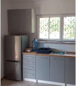 eine Küche mit einem Kühlschrank aus Edelstahl und 2 Fenstern in der Unterkunft Domek w pięknej okolicy 