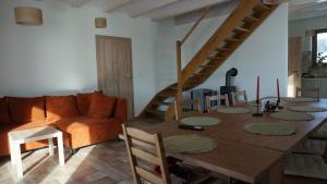 een woonkamer met een houten tafel en een trap bij Domek w Lasówce in Lasowka