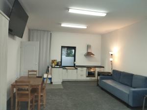 a living room with a blue couch and a tv at Apartament dla par in Olesno