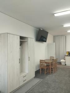 a dining room with a table and a tv on a wall at Apartament dla par in Olesno