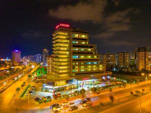 a building with a neon sign on top of it at Anemon Mersin Hotel in Çiftlikköy