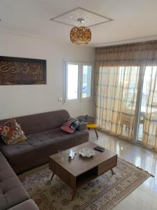 a living room with a couch and a coffee table at Résidence Amwej in Port El Kantaoui