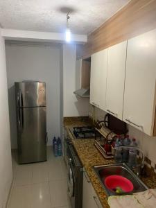 a kitchen with a stainless steel refrigerator and a sink at Résidence Amwej in Port El Kantaoui