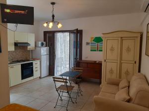 uma sala de estar com um sofá, uma mesa e uma cozinha em Villa Mediterranea em Torre dell'Orso