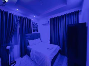 a bedroom with a bed with blue lighting at Oreo by PartyTown in Ankuru