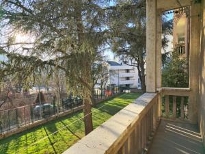 een veranda van een huis met een boom en gras bij Dimora Mafalda in LʼAquila