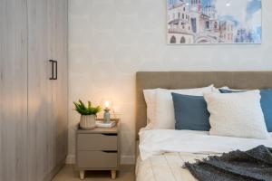 um quarto com uma cama com almofadas azuis e brancas em Mediteranian 1BR in Nusco City em Bucareste