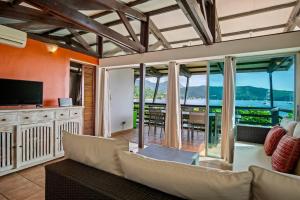 a living room with a couch and a television at Villa Fleur D'eau in Grande Anse