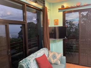 ein Wohnzimmer mit einem Sofa und einem TV in der Unterkunft Anza Cabin at Threesome Cafe in Cebu City