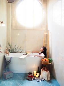 a woman laying in a bath tub in a bathroom at Yada house onsen pool villa in Ban Nong Saeng