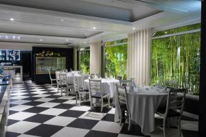 a restaurant with white tables and chairs on a checkered floor at Hotel Cristal Marinha in Marinha Grande +50 photos