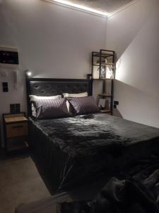 una camera da letto con un grande letto nero in una stanza di Studio Mayer a Patra