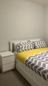a bedroom with a bed with a yellow and white comforter at Luxury 1-Bed Apartment in the heart of Leicester in Leicester