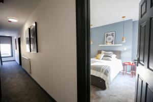 1 dormitorio con 1 cama con pared azul en Contractors Dream 7 bed 7 ensuite en Birkenhead