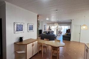 een keuken en een woonkamer met een tafel en stoelen bij Relax @ Jbay in Jeffreys Bay