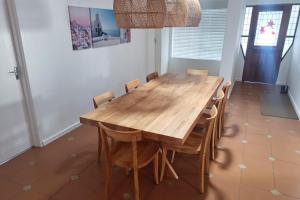 een eetkamer met een houten tafel en stoelen bij Relax @ Jbay in Jeffreys Bay