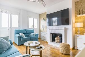 a living room with a blue couch and a fireplace at The Beach -Villa Mar- in Bolnuevo