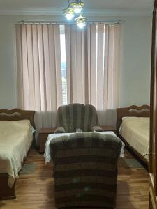 Pokój z 2 łóżkami, 2 krzesłami i lustrem w obiekcie Levon 2 Hotel, Restoran w mieście Noyemberyan