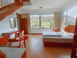 una camera d'albergo con letto, scrivania e finestra di RS Family Stay a Kodaikānāl