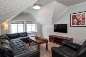 a living room with leather furniture and a flat screen tv at Rjukan Hytteby in Rjukan