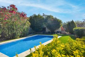 una piscina in un cortile con alberi e fiori di Casa gabriela a Calonge