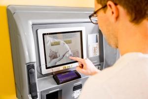 a man is looking at an atm machine at Design Sleepy Cologne in Cologne