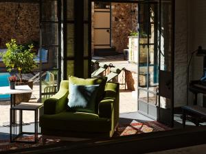 ein Wohnzimmer mit einem grünen Stuhl und einem Tisch in der Unterkunft Not Hotel in Athen
