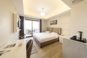 une chambre d'hôtel avec un lit et une table dans l'établissement Anemon Mersin Hotel, à Çiftlikköy
