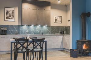 a kitchen with a table and chairs and a stove at Apartamenty Bliżej Nieba - Jagniątków in Jelenia Góra +14 photos