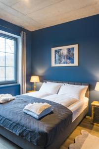 a bedroom with a large bed with blue walls at Apartamenty Bliżej Nieba - Jagniątków in Jelenia Góra