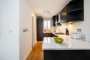 a kitchen with a bowl of fruit on a counter at 2 Bed Flat in Clapham Common in London