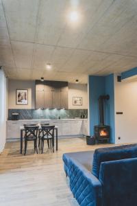 a living room with a couch and a table and a stove at Apartamenty Bliżej Nieba - Jagniątków in Jelenia Góra