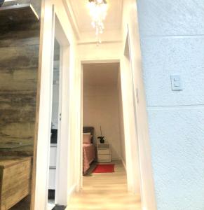 a hallway leading to a room with a bed at Ap no centro com ar condicionado e Garagem Coberta in Cascavel
