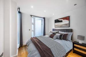a white bedroom with a bed and a window at 2 Bed Flat in Clapham Common in London