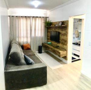 a living room with a couch and a television at Ap no centro com ar condicionado e Garagem Coberta in Cascavel